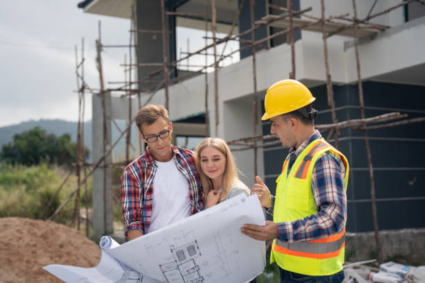 Foreman shows house design plans to a young couple