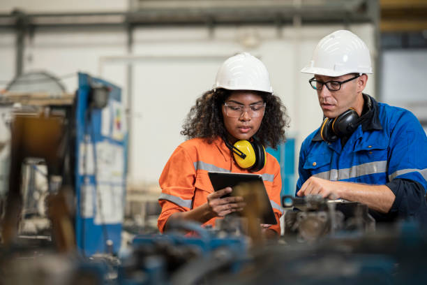 Productivity Improvement of Welding Assembly Lines in Manufacturing Industry. Manufacturing Process Engineers having discussion on welding jig design data to improve and reduce defect loss of work piece in welding process.